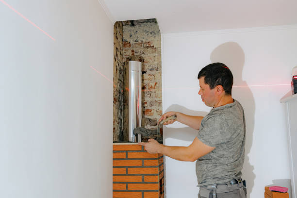 istock A young man makes brickwork on the chimney of a fireplace. 2193461587