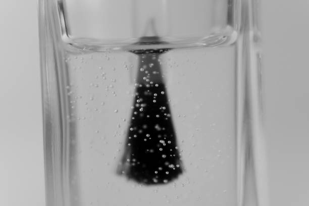 A close-up of the brush in the bottle emphasizes the details of the polish and the gentle shimmer of bubbles floating around.