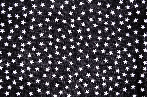 Full frame close-up of black fabric with small white stars background.
