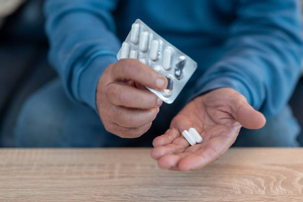 istock Senior man taking pills from blister pack at home 2193464936