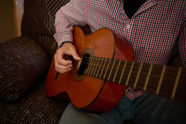 istock Man playing acoustic guitar in a casual home setting. 2193465143
