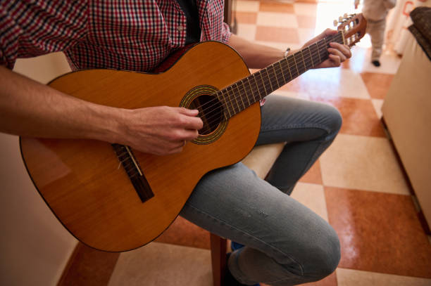 istock Person playing guitar seated in a bright indoor space 2193465224