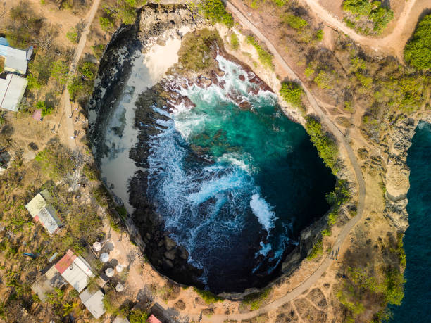 istock Drone shot of ocean waves and a small beach inside a sinkhole (Broken Beach, Nusa Penida) 2193471250