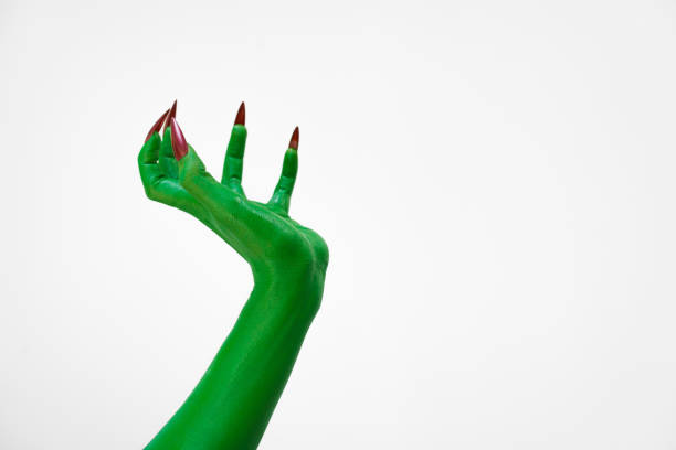 istock Green  female monster hand with sharp nails, isolated on a white background, exudes horror and mystery. Ideal for Halloween, this eerie image depicts undead evil, evoking fear and dark fantasy. 2193483941