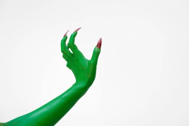 Green  female monster hand with sharp nails, isolated on a white background, exudes horror and mystery. Ideal for Halloween, this eerie image depicts undead evil, evoking fear and dark fantasy.