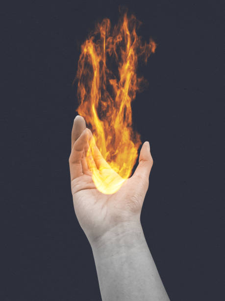 istock Hand holding burning flame and fire isolated on dark background. Symbol of hope. 2193492005