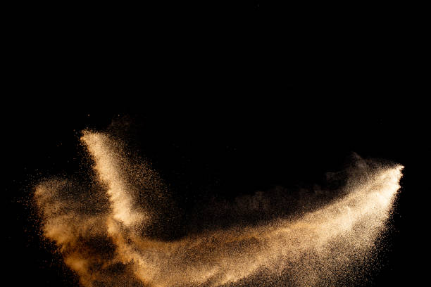 Sand explosion isolated on black background. Freeze motion of sandy dust splash.