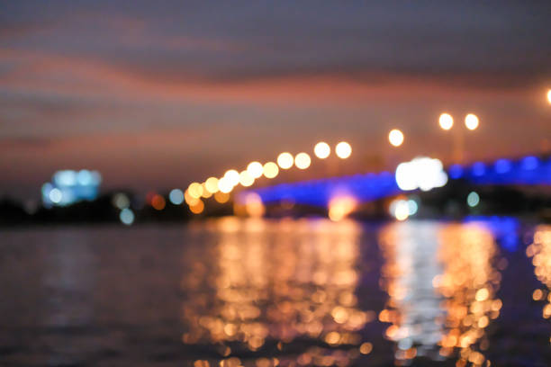 Blurred image bokeh of sunset sky with the bridge and riverside building