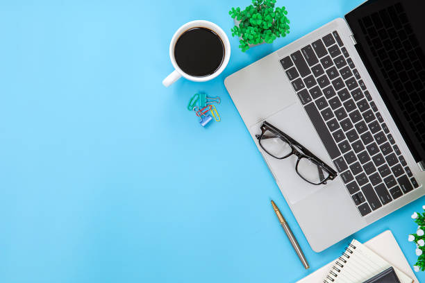 istock Top view desk office workspace and laptop and supply equipment with empty copy space for freelance working productive workplace area or home office flat lay background. 2193495477