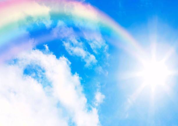 istock Rainbow in the blue sky with clouds and sun. 2193496911