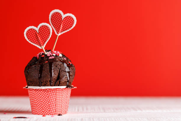 Cupcake love: Heart-themed treats on a vibrant red backdrop