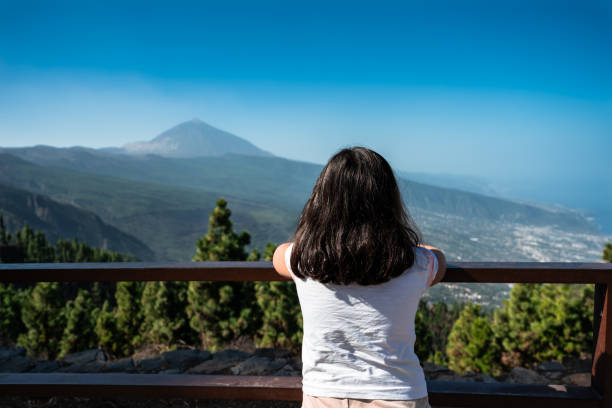 istock A girl is looking out over a mountain range. 2193499567