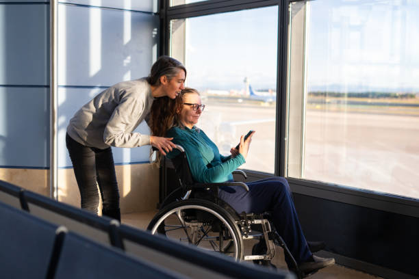 istock Passenger with disability using mobile phone assisted by airport staff 2193499973