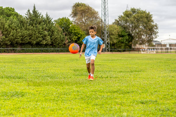 istock Young soccer player training with tethered ball, improving coordination and enjoying outdoor practice on grass field, representing youthful athletic energy 2193504547