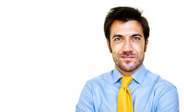 Portrait of a mid-adult businessman smiling confidently while wearing a yellow tie against a clean white background, making direct eye contact with the camera