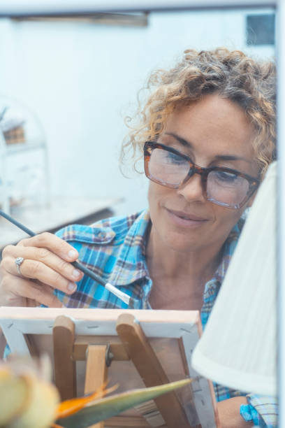 istock Artistic woman painting in a quiet and organized workshop, using professional tools and vibrant colors to create a detailed and expressive piece of art, fully immersed in her creative work 2193509540