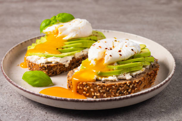 istock Toast with avocado, soft cream cheese, rye bread and poached Egg. Wholemeal open sandwich for healthy breakfast concept 2193509689