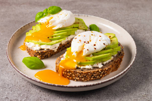 istock Toast with avocado, soft cream cheese, rye bread and poached Egg. Wholemeal open sandwich for healthy breakfast concept 2193509702