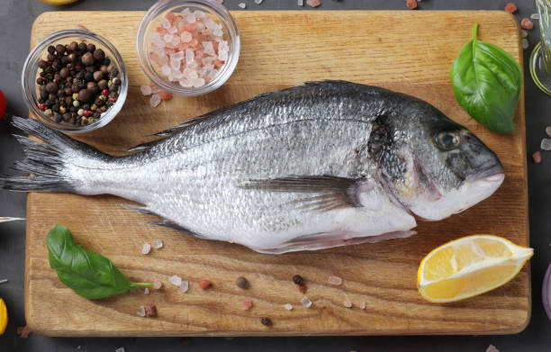 istock Raw dorado fish with spices cooking on cutting board. Closeup. View from above. 2193510089