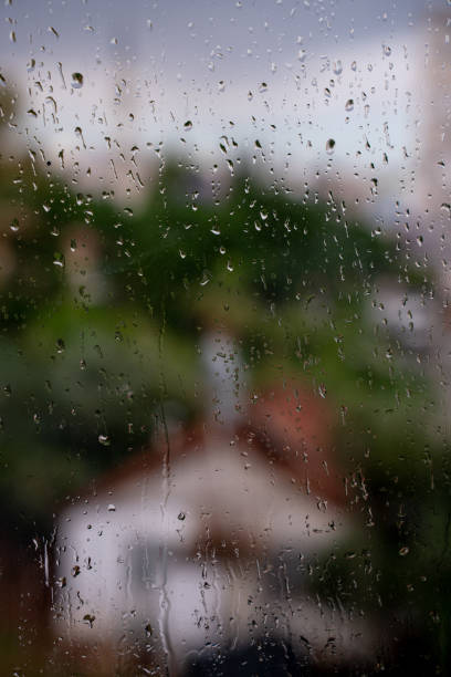istock Raindrops on glass with forest green and blue nature in the background 2193511116