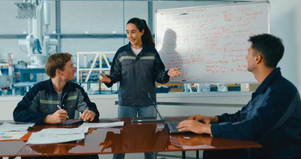 istock Group of engineers having meeting in factory, using whiteboard for discussing project details and planning. Robotic Industrial Factory. 2193512255