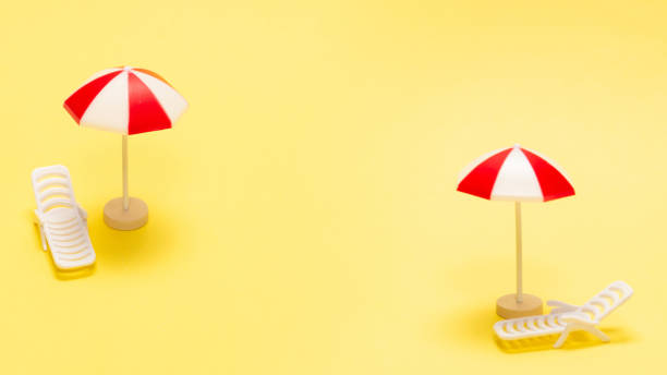 istock Two sun loungers and a red umbrella on a yellow background. 2193512438