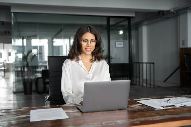istock Smiling young middle eastern business woman specialist working focused on laptop computer. Middle aged latin hispanic investor, bank worker using pc for analysing, network at workplace desk in office 2193514280