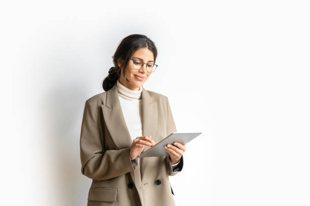 Smiling young middle eastern Israel businesswoman using tablet pc online application for work isolated on white background. Indian or arabic woman in business suit holding digital computer. Copy space