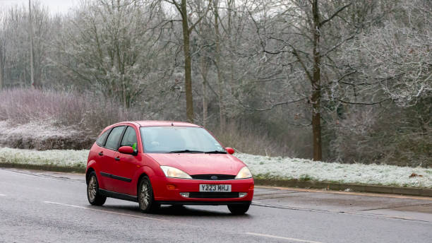 Milton Keynes,UK - Jan 12th 2025: 2001 red Ford Focus car driving on a cold,frosty morning