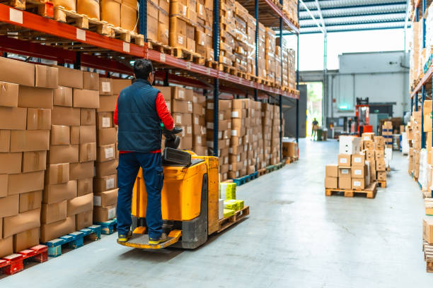 istock Man driving hydraulic hand truck in a distribution warehouse 2193518068