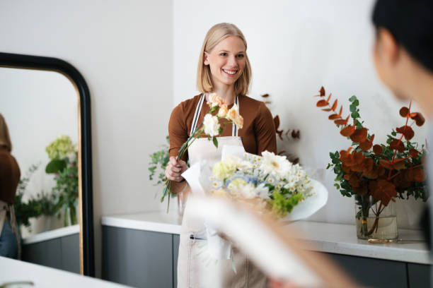 istock Florist Smiling While Preparing a Beautiful Bouquet in a Flower Shop 2193518101