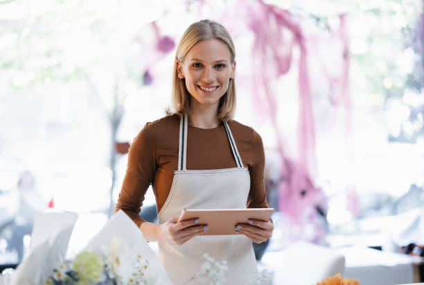 istock Smiling Florist Using Tablet in a Bright Flower Shop Interior 2193518136