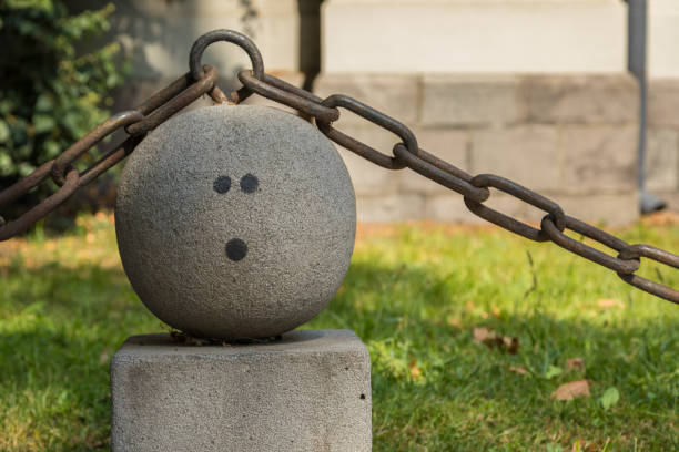 Park fence. Chain with concrete elements. Smiley on a concrete ball. Tbilisi, Georgia.
