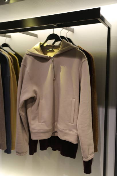 istock A white hoodie is hanging on a rack next to other clothes 2193518336
