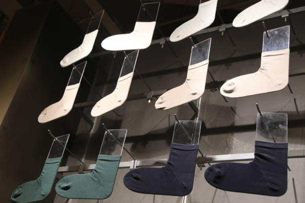A display of socks with different colors and patterns. The socks are hanging on a wall and are arranged in a way that they look like they are on display in a store. The display is organized in rows