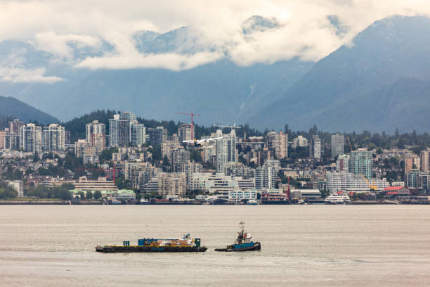 View of a modern city. Burnaby from Canada Place, Vancouver, BC. Water front view with float plane flying. HarbourAir plane.