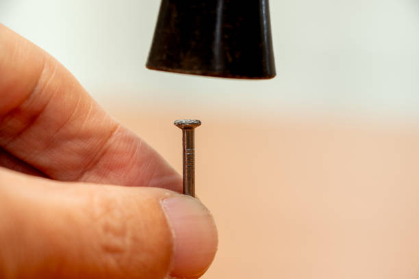 Hammer an iron nail into wood