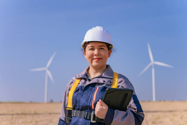 istock Asian Female Engineer in Safety Harness Smiling Confidently While Overseeing Wind Farm Operations, Nakhon Ratchasima, Thailand 2193526415