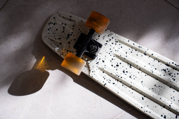 Skateboard details on shadowy ground, colorful wheel, pattern