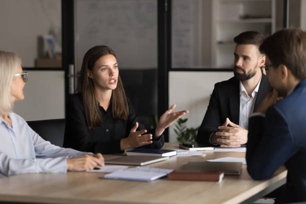 istock Serious young and mature colleagues brainstorm at conference table 2193528176