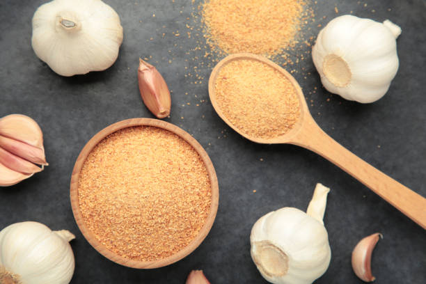 istock Fresh garlic and garlic powder on dark background. Using spices for meals. Top view 2193528331