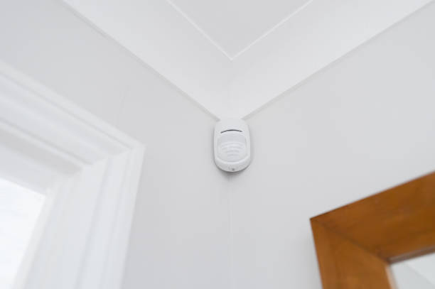 Newly installed wireless and battery operated new generation PIR alarm sensor in a downstairs room. stock photo