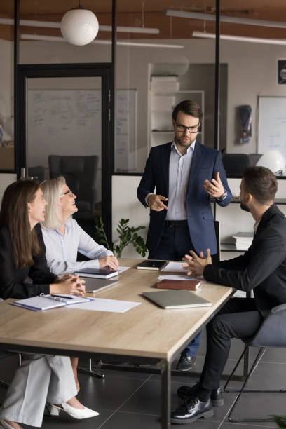 Businessman giving instructions or guiding formal discussion with shareholders