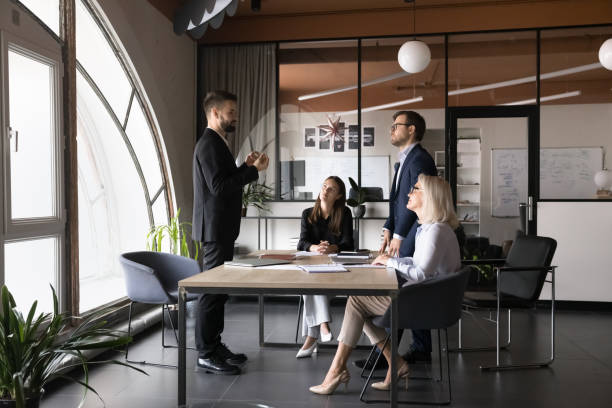 istock Serious team leader talking to colleagues gathered in boardroom 2193532212