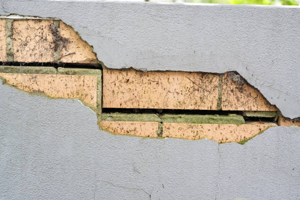 istock A textured rendered brick wall cracked showcasing its rustic surface, ideal for use in design as a grunge wallpaper or vintage background 2193534048