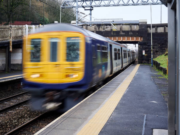 istock Blurred train speeds through a railway station under an overpass on a rainy day. 2193534284