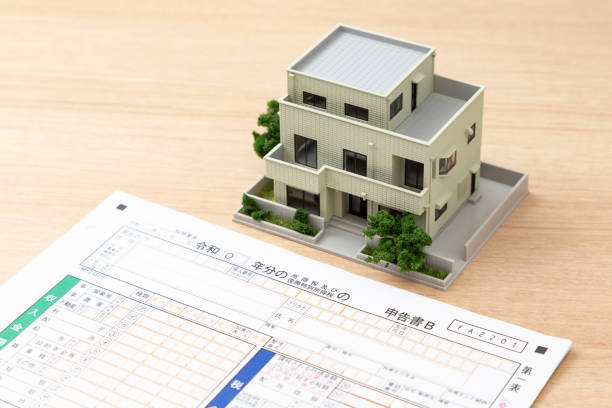 istock Tax return documents and a model house on a desk. 2193539243