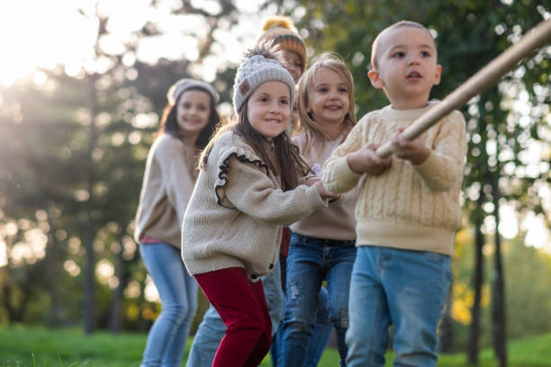 istock happy children playing outside with a rope, pulling the rope 2193541851