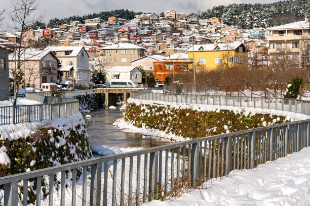 istock Railing. A winter scene from an Istanbul suburb, with snow-covered rooftops and a stream. 2193543597