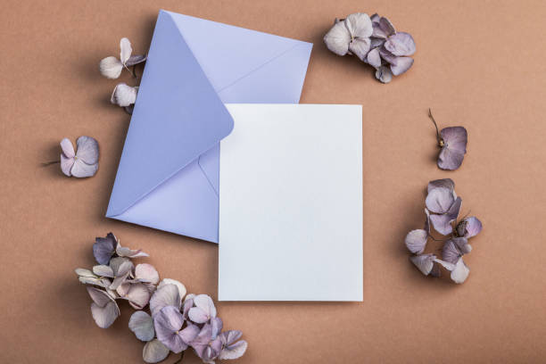 istock Lilac envelope on a brownish background, blank form and hydrangea flowers. Warm earthy tones.Greeting card. 2193543947